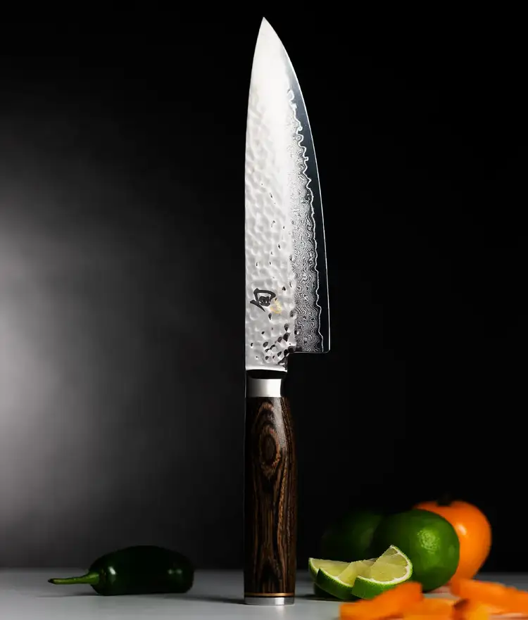 Premier Chefs knife standing vertically on endcap with vegetables and fruit